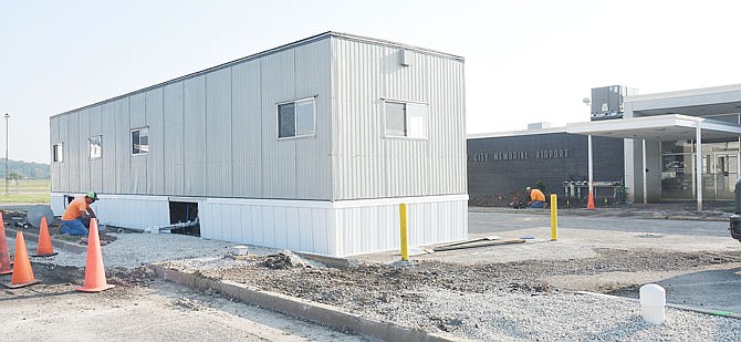 SEPTEMBER 2019 PHOTO: Electricians work to run electric service to the trailer in front of the airport terminal so Ron Craft, manager of Jefferson City Memorial Airport, is able to work on the grounds of the airport again. 