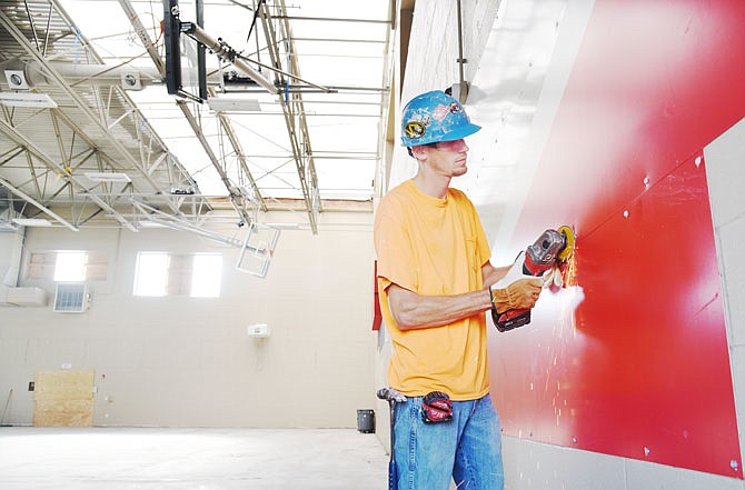 Lorne Lawson, with Reinhardt Construction, uses a cut-off grinder to remove metal signage from the wall of the gymnasium at the Special Olympics Missouri Training for Life Campus. Due to damage from the May 22 tornado, SOMO recently announced it will be moving its State Outdoor Games to elsewhere in Jefferson City.