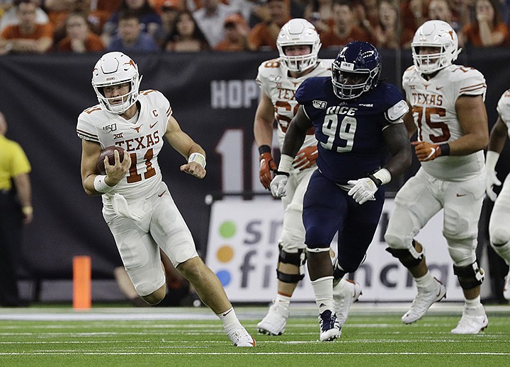 Texas quarterback Sam Ehlinger (11) runs as Rice defensive lineman Myles Adams (99) pursues during the first half of an NCAA college football game Saturday, Sept. 14, 2019, in Houston. (AP Photo/Eric Gay)