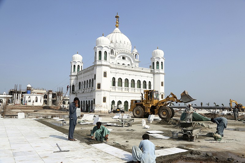 Pakistani workers give finishing touches to the shrine of Sikh spiritual leader Guru Nanak Dev, in Kartarpur, Pakistan, Monday, Sept. 16, 2019. Pakistani officials said Monday that a much-awaited visa-free border crossing for Sikh pilgrims from India will be ready by early November, allowing thousands of pilgrims to easily visit the Sikh shrine just inside Pakistan each day. (AP Photo/K.M. Chaudary)