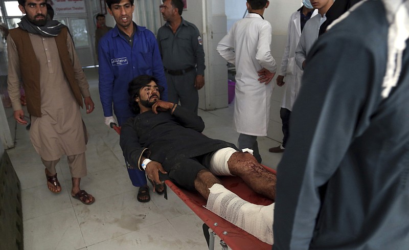 Afghans carry a wounded man into a hospital after a suicide attack in northern Parwan province, Afghanistan, Tuesday, Sept. 17, 2019. The Taliban suicide bomber on a motorcycle targeted presidential guards who were protecting President Ashraf Ghani at a campaign rally in northern Afghanistan on Tuesday, killing over 20 people and wounding over 30. Ghani was present at the venue but was unharmed, according to his campaign chief. (AP Photo/Rahmat Gul)