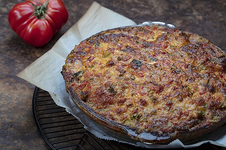 Tomatoes are roasted in the oven to remove most of their water, then layered in a crust with cheese, basil and cracker crumbs and spread with a cheese, pimento and mayo topping. (Brian Cassella/Chicago Tribune/TNS) 