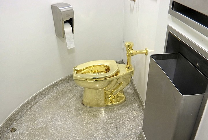 This Sept. 16, 2016 file image made from a video shows the 18-karat toilet, titled "America," by Maurizio Cattelan in the restroom of the Solomon R. Guggenheim Museum in New York. Thieves have stolen the solid gold toilet worth up to 1 million pounds from Blenheim Palace, the birthplace of Winston Churchill. The toilet, the work of Italian conceptual artist Maurizio Cattelan, had been installed only two days earlier at Blenheim Palace, west of London, after previously being on show at the Guggenheim Museum in New York. (AP Photo, File)