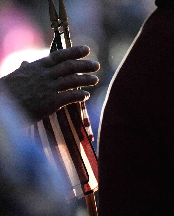 A man holds a mini American flag while waiting for the veterans to return during the Central Missouri Honor Flight welcome home event at the Courtyard Marriott in Columbia on Wednesday, July 05, 2017. 