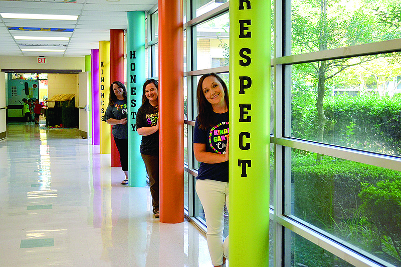 Autumn Brunt Roberts, back, Katherine Brunt Otero and Melissa Brunt Thornberry, front, pose for a group portrait at Pleasant Grove ElementarySchool in Texarkana, Texas. The three sisters all teach at the school.