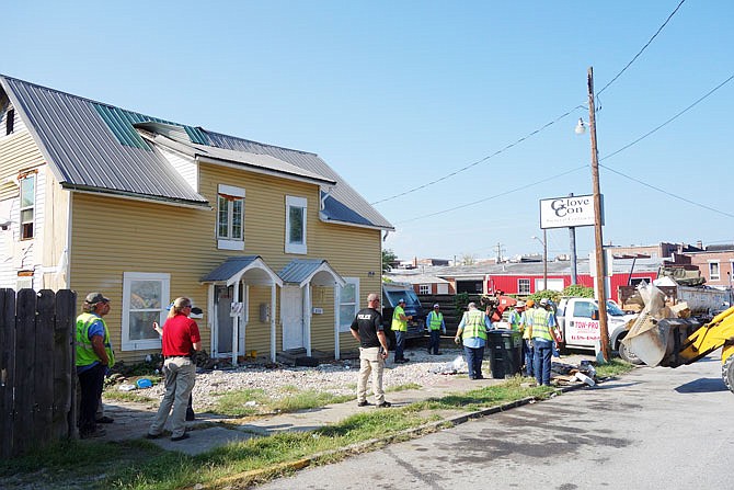 Fulton workers team up to remove battered couches, broken-down vehicles, ancient appliances and more from the yard of Daniel Nash. City administrator Bill Johnson described the property's condition as a "health and safety hazard."