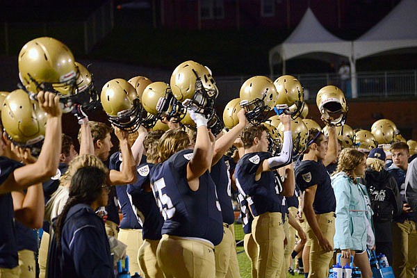 Players on the Helias sideline hold up their helmets during a kickoff in the season opener last month against Hannibal at Ray Hentges Stadium.