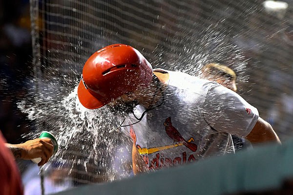 Matt Carpenter is doused with water in the Cardinals dugout after he hit a home run in the top of the 10th inning in Thursday night's game against the Cubs in Chicago.