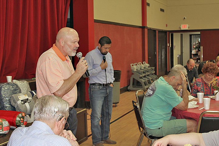 Pastor Jeff Shreve, left, of First Baptist Church, Moores Lane, in Texarkana, Texas, offers a prayer Thursday, September 19, 2019, over the potluck lunch put on by the church for Wagner's Carnival workers, who are providing the midway entertainment at the Four States Fair. Eladio Puente, First Baptist's Spanish missions pastor, right, offered a prayer in Spanish. Staff photo by Junius Stone