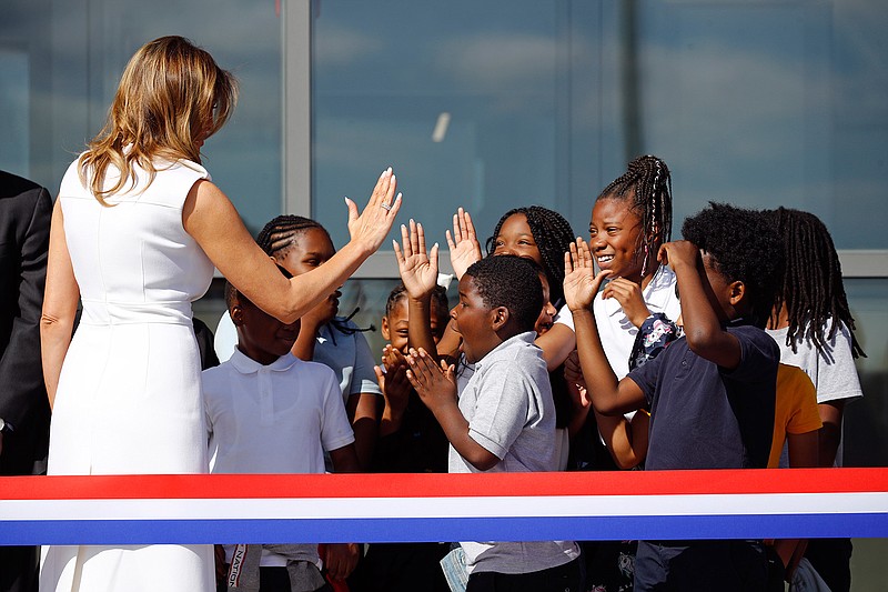 First lady Melania Trump high-fives students from Amidon-Bowen Elementary School in Washington on Thursday as she arrives at a ribbon-cutting ceremony to reopen the Washington Monument. The monument has been closed to the public for renovations since August 2016. 