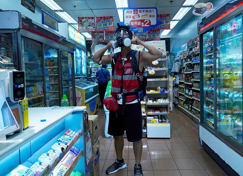 A first aid person wears a gas mask in a convenience store as the protest continues on the streets of Hong Kong on Saturday, Sept. 21, 2019. Protesters in Hong Kong threw gasoline bombs and police fired tear gas Saturday in renewed clashes over anti-government grievances. (AP Photo/Vincent Yu)