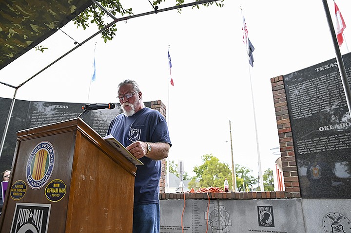 Greg Beck speaks to those gathered for the 32nd annual POW-MIA Vigil on Friday at the Korea-Vietnam Memorial at West Seventh Street in Texarkana. The vigil started with a short opening ceremony and continued through the night with a candlelight vigil in honor of those who sacrificed their lives in service to the country. Staff photo by Hunt Mercier