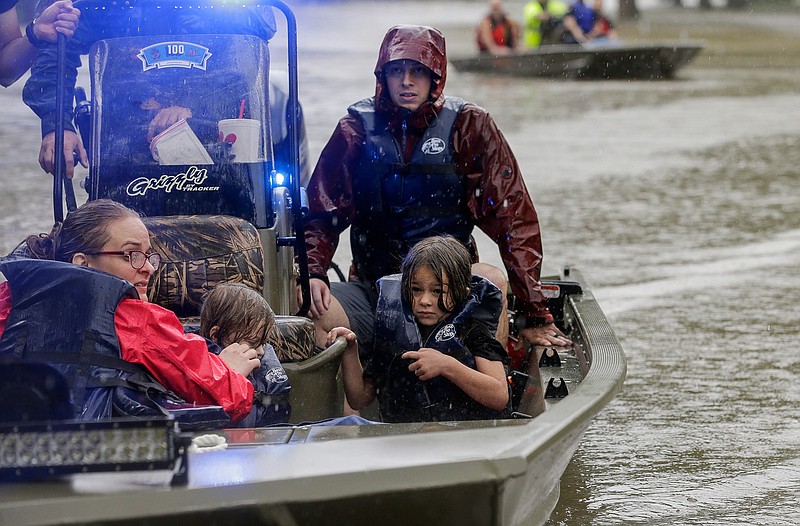 First responders with the Harris County Sheriff's Office, Texas Game Warden, and Huffman Fire Department rescue people from flooded homes Friday in the Lochshire neighborhood in Huffman, Texas. Emergency workers used boats Friday to rescue about 60 residents of the Houston-area community who were still trapped in their homes by floodwaters following one of the wettest tropical cyclones in U.S. history.