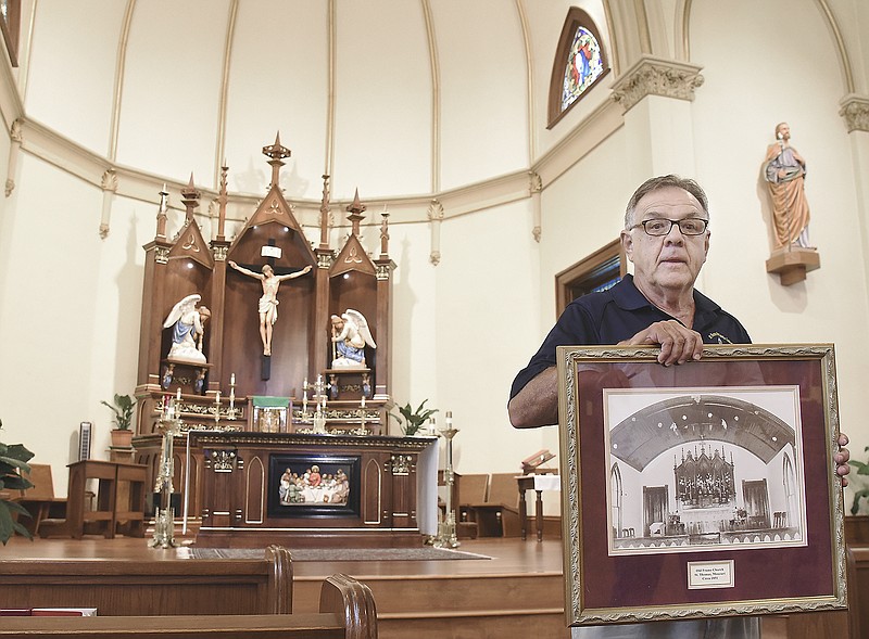 Bill Boessen holds up a framed photograph of the original church sanctuary in St. Thomas. Boessen, who along with other volunteers spoke about the upcoming sesquicentennial celebration. St. Thomas the Apostle Catholic Church in St. Thomas, which was the center of activity for many years as is evidenced by some of the memorabilia kept at the Cole County church. 