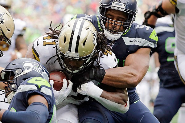 Bobby Wagner of the Seahawks tries to stop Alvin Kamara of the Saints on a carry during the second half of Sunday's game in Seattle.