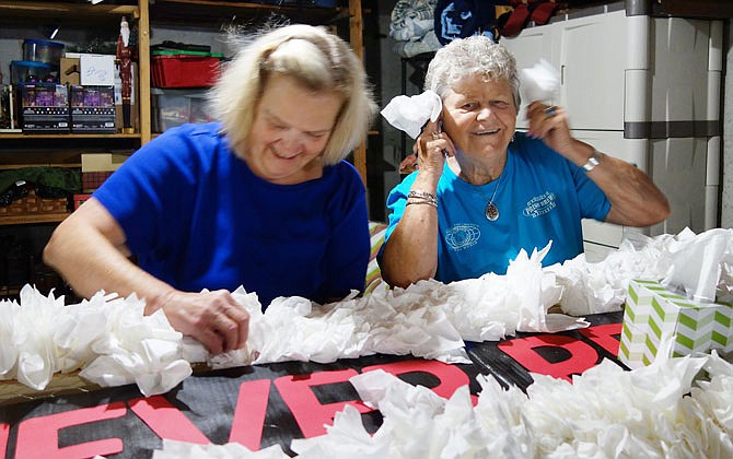 Retired Jefferson City High School teacher Linda Ringo, right, has some fun while she and Janet Johnson work on a parade float. They were among several dozen retired Jefferson City School District faculty and staff who spent numerous hours building a float for tonight's annual JC Schools homecoming parade.