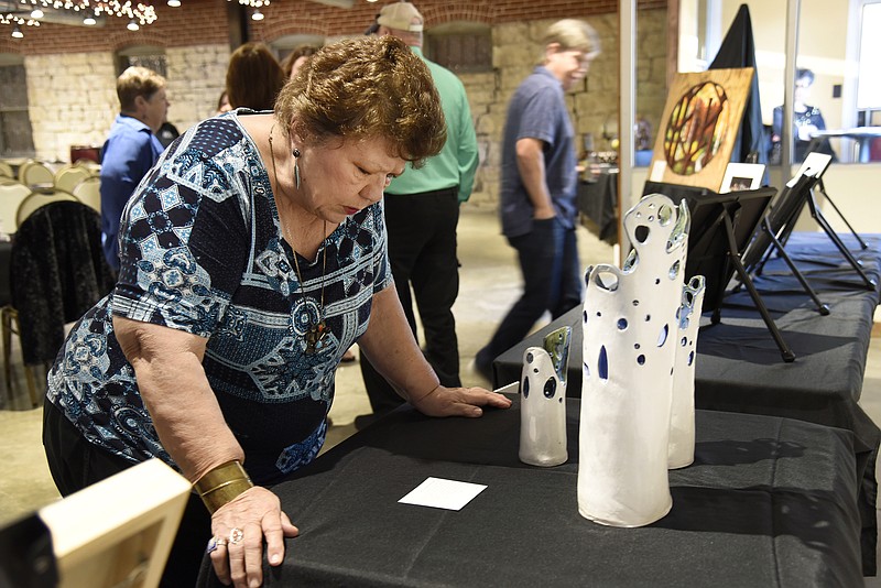 <p style="text-align:right;">News Tribune file</p><p><strong>Roberta Dunkel looks at a set of sculptures called “Trio” done by Dr. Chandra Prasad at the third annual CelebARTy Dinner and Live Art Auction in 2018. The fourth annual event is set for Oct. 3 at Revel Catering.</strong></p>