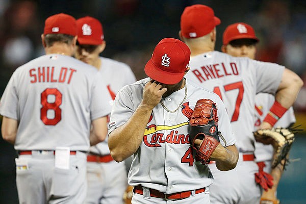 Cardinals relief pitcher Junior Fernandez walks back to the dugout after being taken out in the sixth inning of Wednesday afternoon's game against the Diamondbacks in Phoenix.