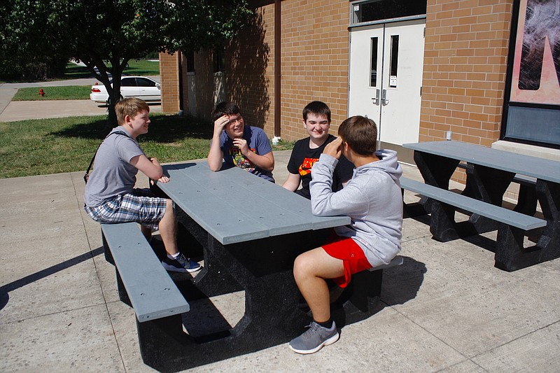 <p>Quinn Wilson/For the News Tribune</p><p>New Bloomfield High School students Nathan Mueller, Ethan Hake, James Wilson and Michael Leason enjoy the district’s new majority recycled tire tables purchased with a $12,000 grant from the Missouri Department of Natural Resources. The district purchased 23 tables and benches with the grant money.</p>