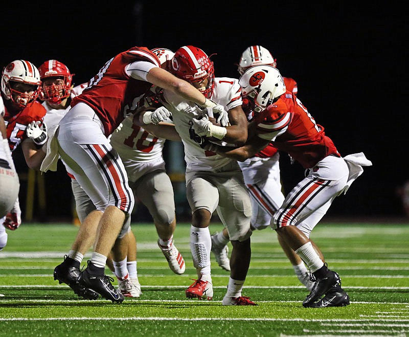 Jefferson City linebacker Alex Burkhead and defensive back Darrell Jones try to bring down Chaminade running back Amar Johnson during Friday night's Homecoming game at Adkins Stadium.