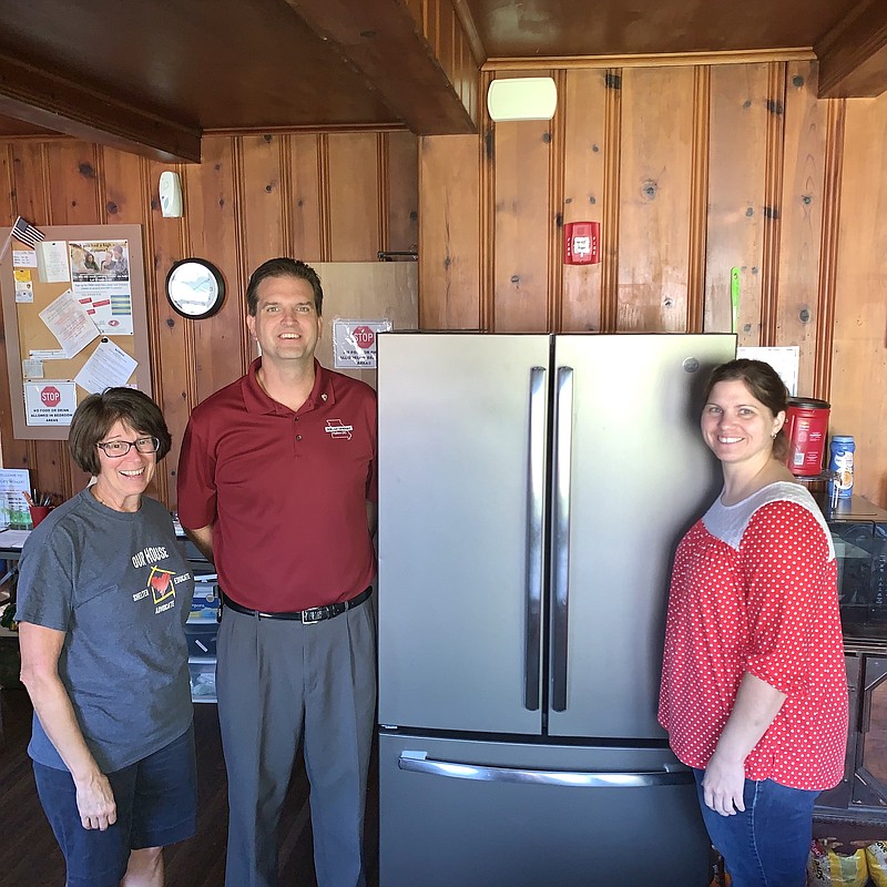 Our House board President, Rachel Salmons; Fulton Rotary Club President, Allen Huggins; and Our House Executive Director, Misty Dothage, stand in front of Our House's new fridge. Our House received a $1,000 grant from Fulton Rotary Club that allowed them to purchase the fridge.
