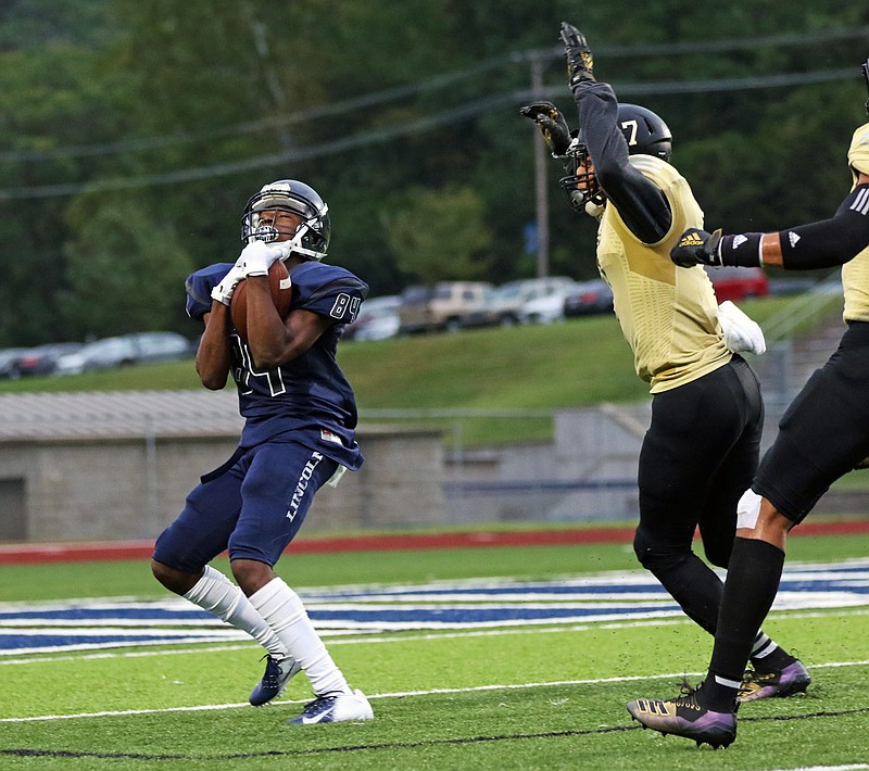 Lincoln receiver Chrisshun Robinson hauls in a 35-yard touchdown past Emporia State defensive back Jordan Wallace during Saturday night's game at Dwight T. Reed Stadium.