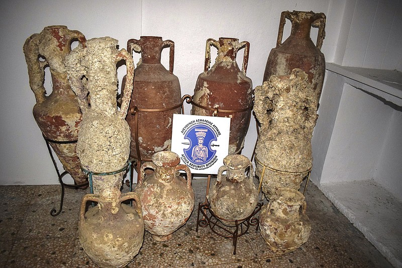 In this undated photo released Monday Sept. 30, 2019, by Greek police, showing ancient amphoras used to transport wine, olive oil and other foodstuffs.  In a statement released Monday Sept. 30, 2019, Greek police say they have arrested three men on the Aegean island of Kalymnos for allegedly plundering ancient shipwrecks and removing more than two dozen intact pottery vases dated from the 4th Century B.C. to the late Middle Ages. (Greek Police via AP)