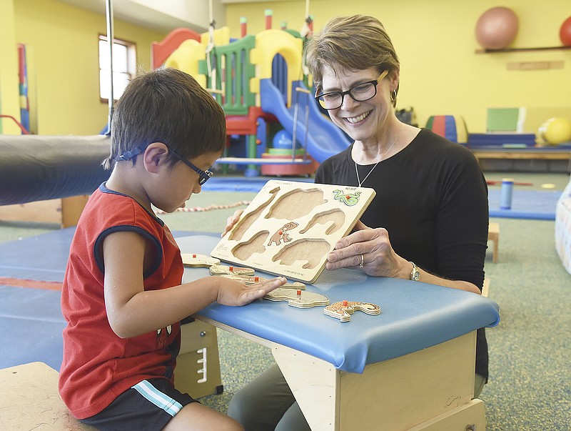 Speech pathologist Linda Kuebler works with Oscar Moreno on Monday at The Special Learning Center. Kuebler was working with Moreno in the large, brightly lit colorful room which was made possible by donations from Tom Henke and the Jefferson City Cosmopolitan Club which work together to put on the Tom Henke Charity Golf Classic each fall for more than 20 years. Not only was this room made possible but the entire additional wing which now serves as a therapy wing was made possible by those donations.