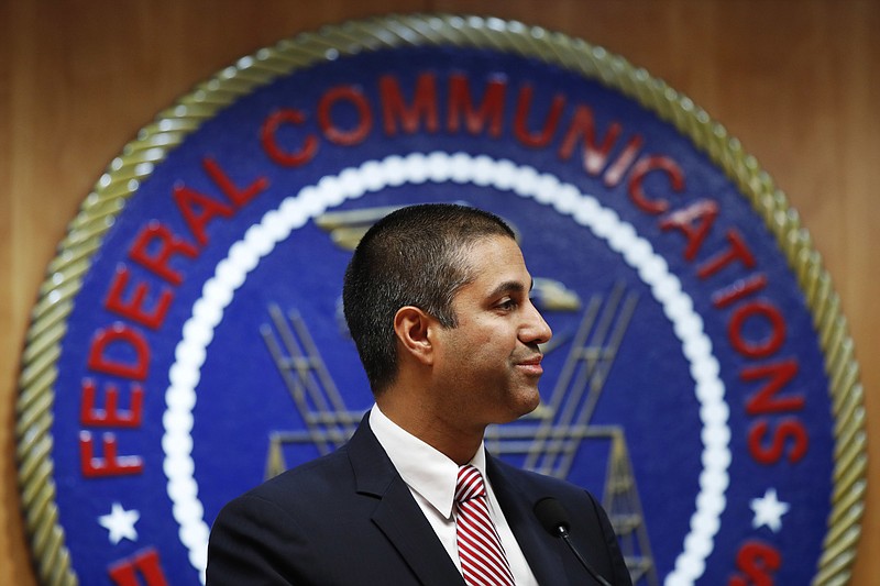 FILE - In this Dec. 14, 2017, file photo, after a meeting voting to end net neutrality, Federal Communications Commission (FCC) Chairman Ajit Pai smiles while listening to a question from a reporter in Washington.  A federal court is ruling that the FCC had the right to dump net-neutrality rules, but couldn't bar states like California from passing their own. The ruling is largely a victory for Pai. (AP Photo/Jacquelyn Martin, File)