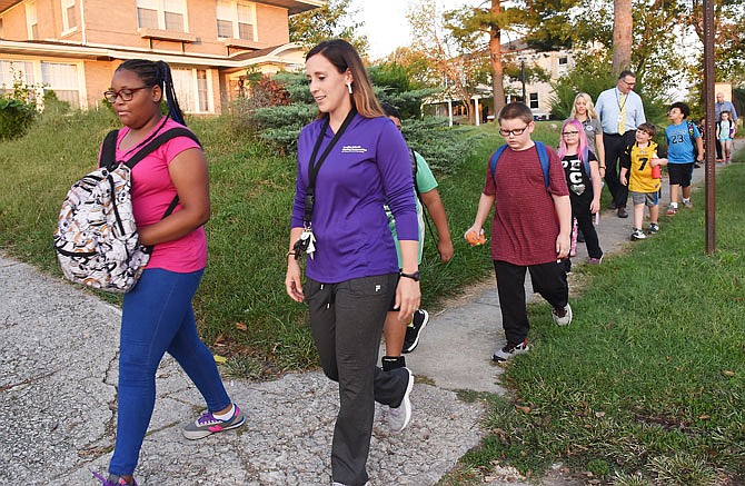 Alyssa Wyms, left, and Kelsey Chrisman, Healthy Schools coordinator for the district, lead a group of students Wednesday on their way to Thorpe Gordon Elementary School. 