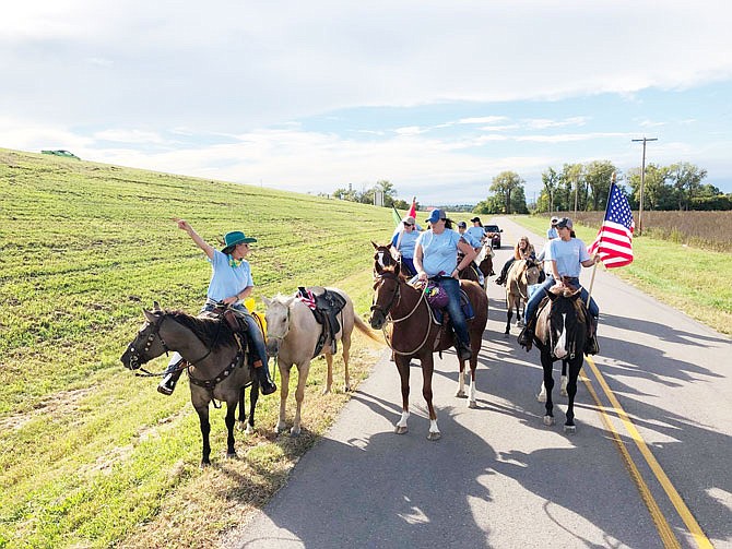 Riders in the 2018 Angels for Autism Hoof-A-Thon hoof it down the road near Holts Summit. The annual charitable event supports horseback riding therapy for children and adults with autism.