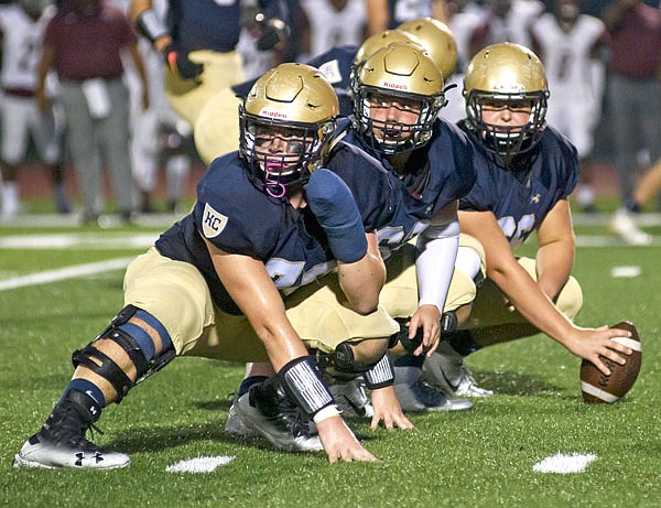 The Helias offensive line looks to the sideline for the play call during the first half of a game earlier this month against Cardinal Ritter at Ray Hentges Stadium.