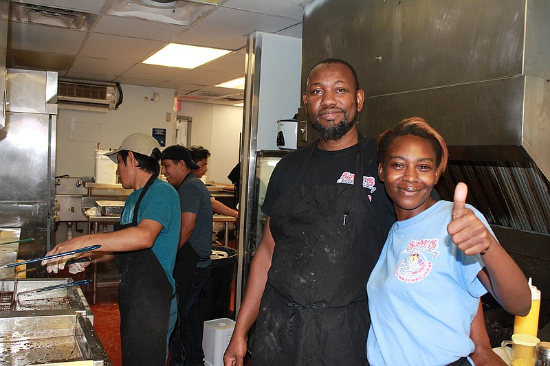 Yusef Kone, co-owner, middle, and Lamisha Wilson, floor manager/customer service, show off the kitchen of Sam's Southern Eatery on New Boston Road. Open since mid-September, the Cajun-style fast food eatery is the only Sam's that uses the Sonic model of drive-in ordering.