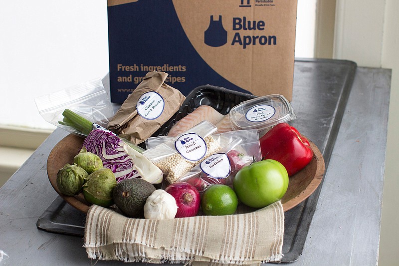 This Oct. 6, 2014, file photo shows an example of a home-delivered meal from Blue Apron. The growing options for outsourcing meal planning, grocery shopping and cooking can be called time-saving blessings or culture-destroying curses. In the end, they're probably a complicated mix of both. (AP Photo/Matthew Mead, File)