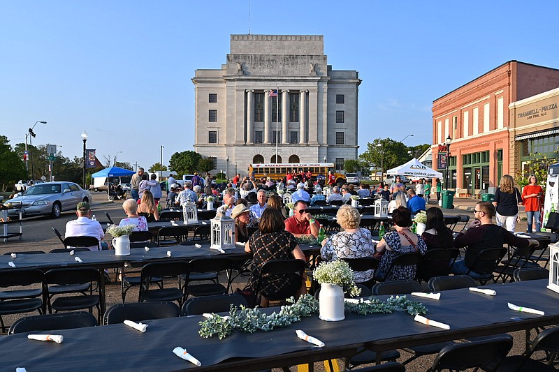 People sit at dinner tables placed on the state line of Arkansas and Texas on Friday in downtown Texarkana. Dine on the Line, a two-state, two-city event, encourages the community to come together and promote Texarkana. The event featured food, drinks and live music.