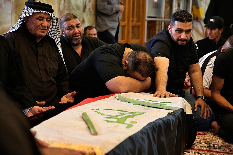 Mourners pray over the flag-draped coffin of a protester killed during anti-government protesters during his funeral at the Imam Ali shrine in Najaf, Iraq, Saturday, Oct. 5, 2019. The spontaneous protests which started Tuesday in Baghdad and southern cities were sparked by endemic corruption and lack of jobs. Security responded with a harsh crackdown, leaving more than 70 killed. (AP Photo/Anmar Khalil)