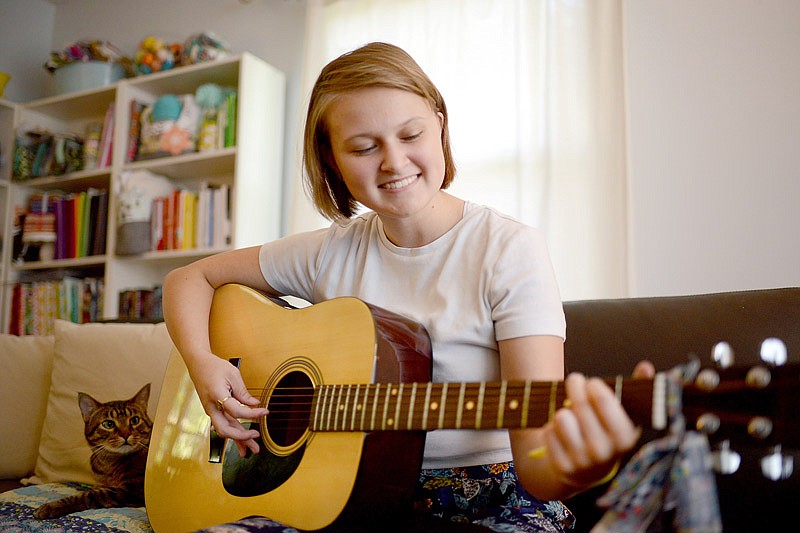 Erin Lammers plays a song on her guitar Tuesday September 10, 2019 as she sits in the living room of her family home. Lammers is a local musician and Helias student who writes and records her own music and recently became a start-up artist on Spotify. 