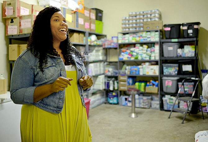 Executive Director Alicia Edwards shows a portion of the food pantry Friday as she gives a tour inside the Building Community Bridges building. The organization has partnered with the Food Bank for Central and Northeast Missouri since November and has served hundreds of residents in need since the May 22 tornado.