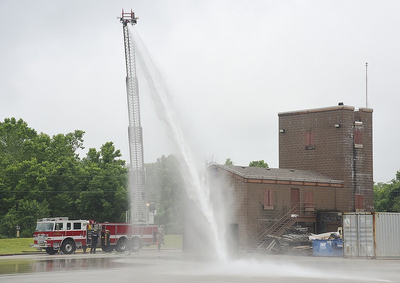 Julie Smith/News Tribune  June 2019 File Photo
Rookie firefighter training at Hyde Park, learning to use and control nozzle spray on a ladder truck. To the right in the photograph is the burn building and tower, which have been deemed unsafe to use and has been closed to training. Jefferson City Council is trying to find money in the budget to replace this part of the Hyde Park Training Facility. 