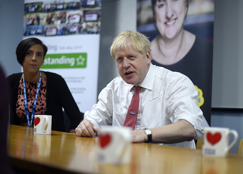 Britain's Prime Minister Boris Johnson speaks to health professionals as he visits Watford General hospital, England, Monday Oct. 7, 2019. The UK government has pledged billions for new hospital projects across England under plans devised up by Health Secretary Matt Hancock. (Peter Summers/Pool via AP)