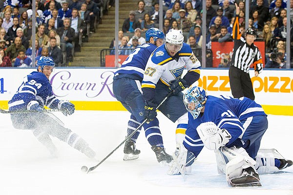 David Perron of the Blues tries to control the puck in front of Maple Leafs goaltender Frederik Andersen during the third period of Monday night's game in Toronto.