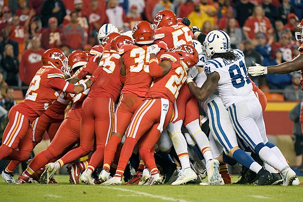 A scrum of Chiefs players attempt to stop the Colts' offense near the line of scrimmage during the second half of Sunday night's game at Arrowhead Stadium.