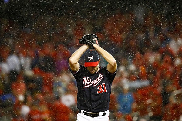 Nationals starting pitcher Max Scherzer winds up to throw in the rain during the sixth inning of Monday night's Game 4 of the National League Division Series against the Dodgers in Washington.