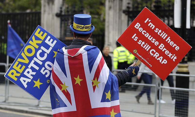 Anti-Brexit campaigner Steve Bray walks near Parliament in London, Tuesday, Oct. 8, 2019. The British government said Tuesday that the chances of a Brexit deal with the European Union were fading fast, as the two sides remained unwilling to shift from their entrenched positions. (AP Photo/Kirsty Wigglesworth)