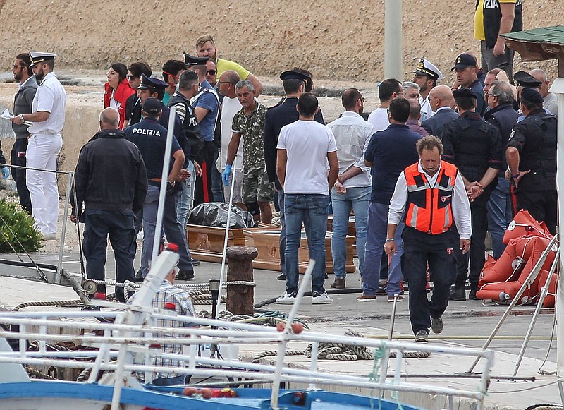 Coffins are prepared on the dock of the tiny island of Lampedusa, Sicily, in southern Italy, Monday, Oct. 7, 2019. At least 13 people died when an overloaded migrant boat capsized near the island of Lampedusa as they were about to be rescued, the Italian Coast Guard said Monday. Twenty-two people were rescued from the sea and taken to land. (Pasquale Claudio Montana Lampo/ANSA via AP)