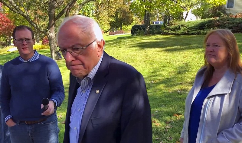 In this image taken from video, Democratic presidential candidate Sen. Bernie Sanders, I-Vt., speaks we reporters outside his home, Tuesday, Oct. 8, 2019, in Burlington, Vt. His wife, Jane O'Meara Sanders listens at right. Sanders says he was "dumb" not to have listened to the symptoms he was experiencing before he was stricken with a heart attack last week. (AP Photo/Wilson Ring)