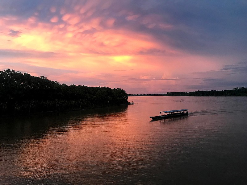 A boat coasts along the Huallaga River at sunset near the Peruvian town of Yurimaguas, the starting point for a trip down the Amazon to Iquitos. (Photo for The Washington Post by Emily Gillespie)