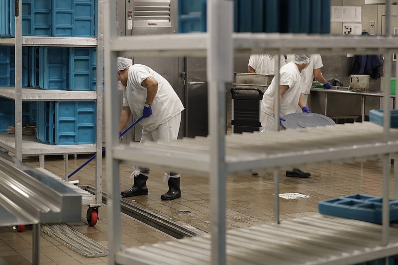 FILE - In this file photo taken Sept. 10, 2019, workers are shown in the kitchen of the U.S. Immigration and Customs Enforcement (ICE) detention facility in Tacoma, Wash. during a media tour. Washington state's effort to force a privately run immigration jail to pay its detainees minimum wage for work they perform can continue, after all. U.S. District Judge Robert Bryan in Tacoma said last month that he intended to dismiss the case, and he invited state Attorney General Bob Ferguson and lawyers for the GEO Group, which runs the detention center, to comment on a proposed order he planned to file. (AP Photo/Ted S. Warren,File)