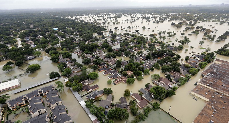 FILE - In this Aug. 29, 2017, file photo, a neighborhood near Addicks Reservoir is flooded by rain from Tropical Storm Harvey in Houston. A new study finds that FEMA buys flood-prone homes more often in wealthy, populous counties than in poor, rural areas, even though lower-income rural areas may be more likely to flood frequently. Harris County, Texas, where Houston is located, which, according to its flood control district, undergoes a major flood about every two years, has used FEMA’s buyout programs more than any other county, the researchers said. (AP Photo/David J. Phillip, File)