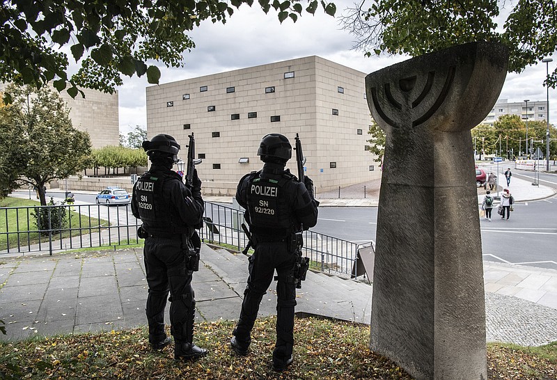 CORRECTS CITY TO DRESDEN -- Police officers secure a synagogue in Dresden, Germany, Wednesday, Oct. 9, 2019. One or more gunmen fired several shots on Wednesday in the German city of Halle. Police say a person has been arrested after a shooting that left two people dead. (Robert Michael/dpa via AP)